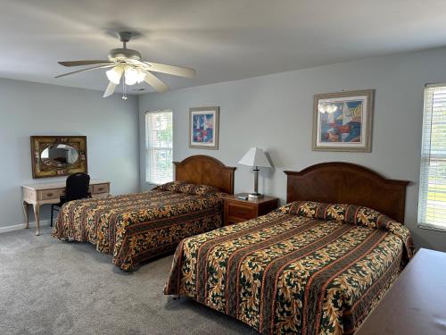 1 dormitorio con 2 camas y ventilador de techo en Pirates Cove, en Carolina Beach