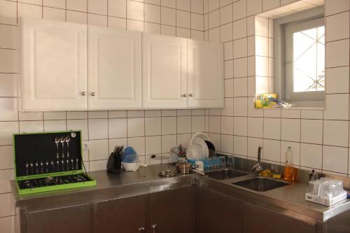科英布拉的住宿－BE科英布拉旅舍，厨房配有水槽和台面上的笔记本电脑