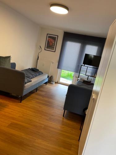 a bedroom with a bed and a couch and a window at -Bella Casa- Central Studio Apartment in Fürth