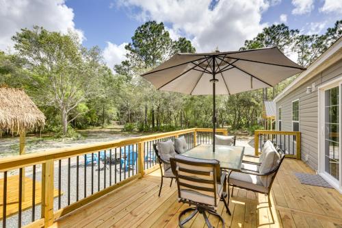 a deck with a table and chairs and an umbrella at Charming Perry Home about 2 Mi to the Gulf! in Perry