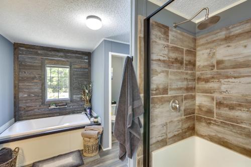 a bathroom with a tub and a shower with wooden walls at Charming Perry Home about 2 Mi to the Gulf! in Perry