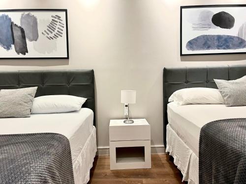 1 dormitorio con 2 camas y mesita de noche entre ellas en Flat 2 quartos, novo, na Avenida Paulista, en São Paulo