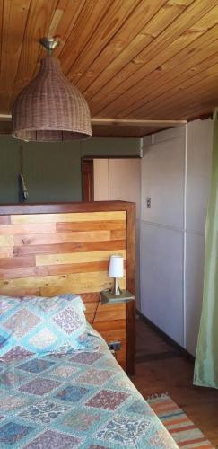 a bedroom with a bed and a wooden ceiling at Cabañas & SPA Carilafquen in Laguna Verde
