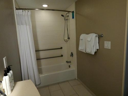 a bathroom with a tub and a shower with towels at SpringHill Suites by Marriott Corpus Christi in Corpus Christi