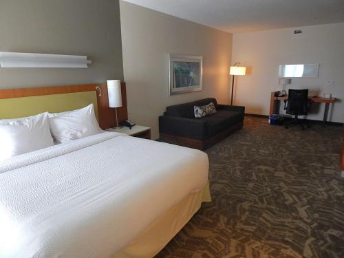 une chambre d'hôtel avec un lit et un canapé dans l'établissement SpringHill Suites by Marriott Corpus Christi, à Corpus Christi