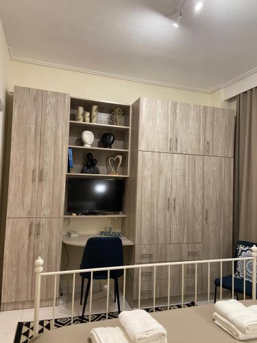 a room with wooden cabinets and a desk with a chair at Zoi's central home in Volos