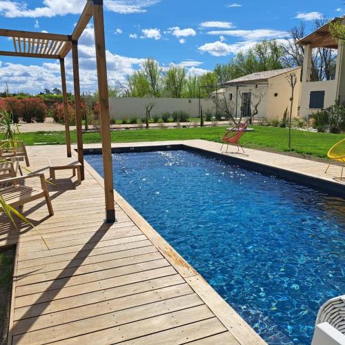 une piscine avec une terrasse en bois à côté d'une maison dans l'établissement Studio en campagne, à Avignon