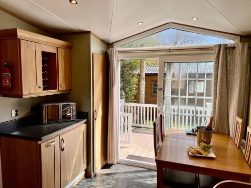 a kitchen with a table and a sliding glass door at Leaf Lane Lodge in Newton on the Moor