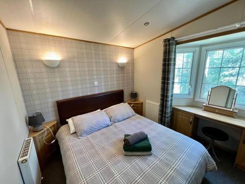 a bedroom with a bed with a pillow on it at Leaf Lane Lodge in Newton on the Moor
