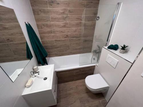 a bathroom with a sink and a toilet and a shower at City center apartment with nice balcony in Žilina