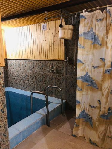 a bathroom with a tub and a shower curtain at Карпатська Модрина in Kosiv