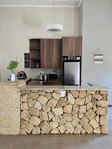 uma cozinha com um balcão de pedra num quarto em Pine View Guesthouse Graskop em Graskop