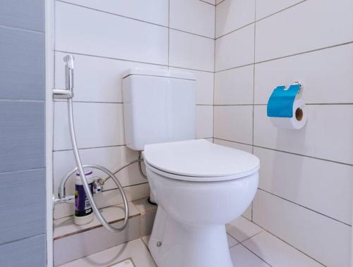 a bathroom with a white toilet in a white tiled wall at B8 Studio, Apt 22, Mwangani Apartments in Fumba