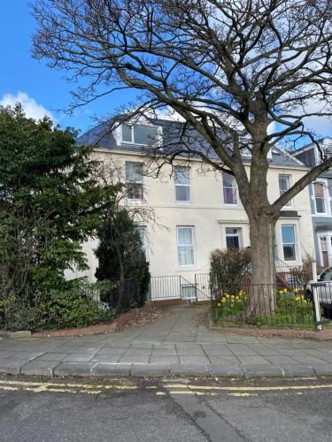 Una casa blanca con un árbol delante. en Moor View Apartment, near city centre and stadium en Town Moor