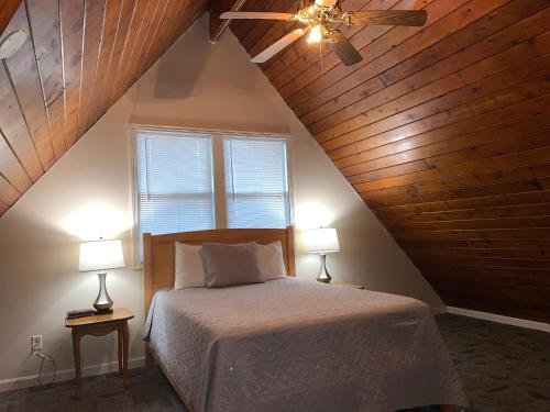 una camera con un letto, un ventilatore a soffitto e 2 lampade di Courtyard Resort a Hyannis