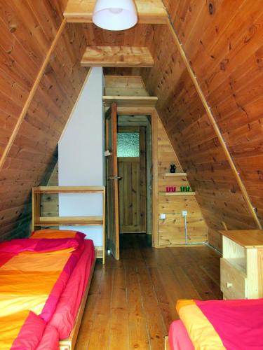 a room with two beds in a wooden cabin at Jeżówka in Sasino