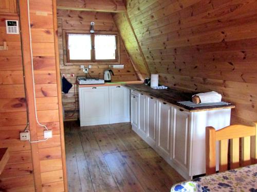 a kitchen in a log cabin with a counter at Jeżówka in Sasino