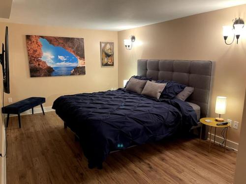 een slaapkamer met een bed met een blauw dekbed bij Lovely oceanside 1-bdrm suite Fireplace HotTub in Crofton
