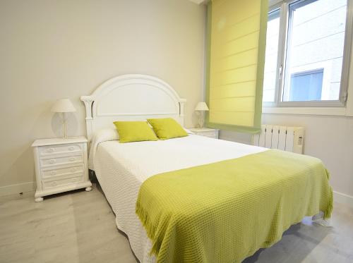 a bedroom with a large bed with a yellow blanket at Apartamento en pleno centro de Portonovo, Sanxenxo in Sanxenxo