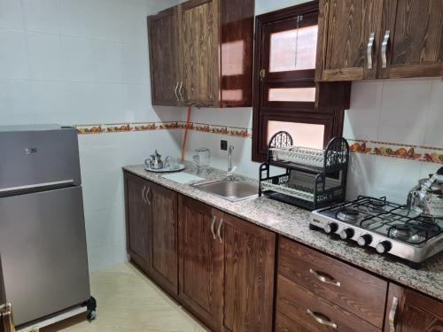 uma cozinha com armários de madeira, um lavatório e um frigorífico em Restaurante Cafe El Balcon 