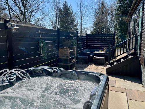 a hot tub on a patio with a fence at Barnston Lodge in Newton on the Moor