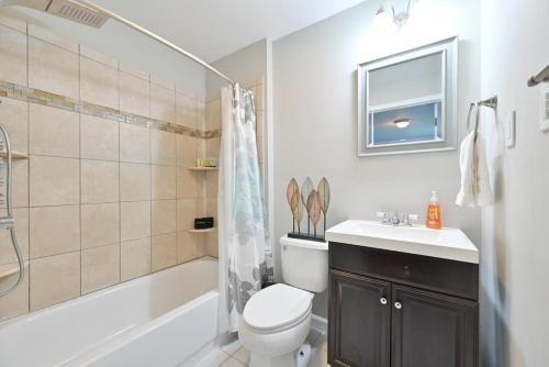 a bathroom with a toilet and a sink and a tub at 653 3rd St Unit 2 After Dune Delight in Somers Point