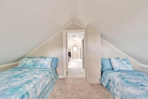 a attic bedroom with two beds and a hallway at 653 3rd St Unit 2 After Dune Delight in Somers Point