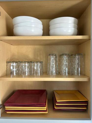 a cabinet filled with plates and bowls and dishes at 653 3rd St unit1 AfterDune Delight 2BR Near Beach in Somers Point