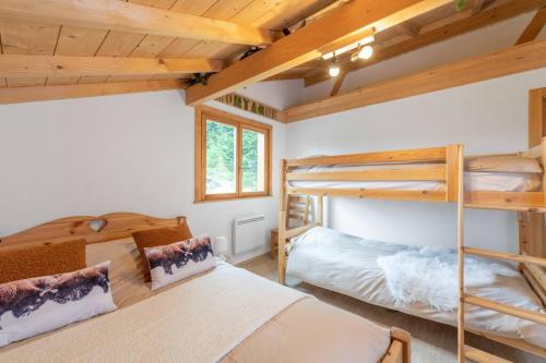 two bunk beds in a room with wooden ceilings at L’Ecrin Blanc – Cocon familial avec jacuzzi et salle de jeux in Liézey