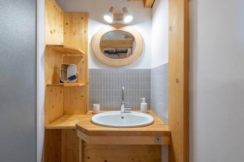a bathroom with a sink and a mirror at L’Ecrin Blanc – Cocon familial avec jacuzzi et salle de jeux in Liézey
