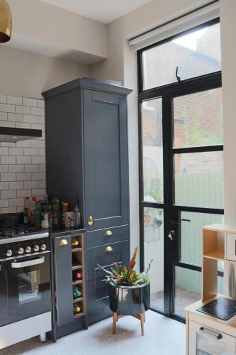 a black cabinet in a kitchen with a window at Beautiful maisonnette flat in Islington in London