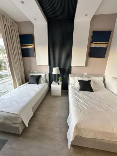 2 camas en un dormitorio con una pared en blanco y negro en LUXURY CONDO Cana Bay 1 CLUB BEACH, en Punta Cana