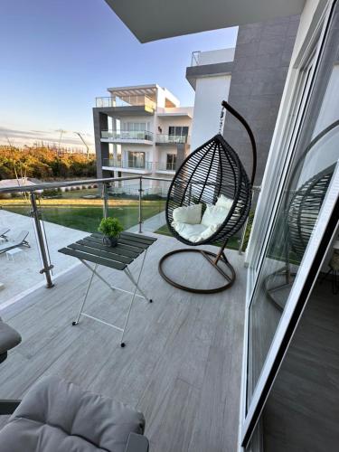 a patio with a swing chair on a balcony at LUXURY CONDO Cana Bay 1 CLUB BEACH in Punta Cana