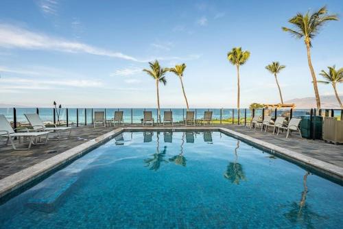 uma piscina com palmeiras e o oceano em Escape to Your Oceanside Dream in Kihei em Kihei
