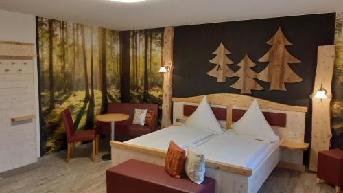1 dormitorio con 1 cama y una pared con árboles en Landhaus Sonnentau, en Johanngeorgenstadt