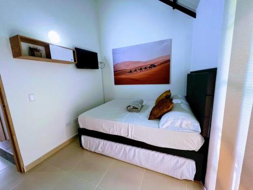a bedroom with a bed with a painting on the wall at Apto Nuevo, Tranquilo, Bonito, 5 min Plaza Principal in Guatapé