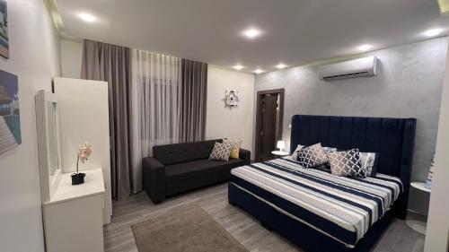 niewielka sypialnia z łóżkiem i kanapą w obiekcie Taj Villa deadsea - Entire Villa with sea view w mieście Swemeh