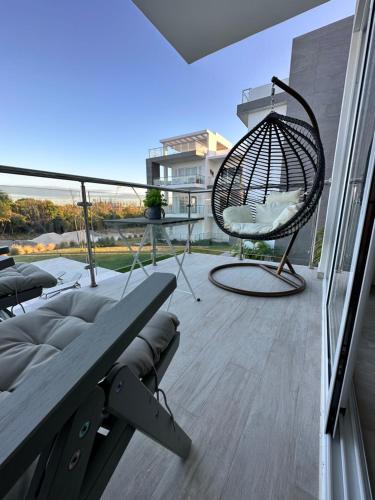 a balcony with a swing chair and a table at LUXURY CONDO Cana Bay 1 CLUB BEACH in Punta Cana