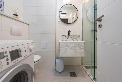 y baño con lavadora y espejo. en Urban Vibe Zadar, en Zadar