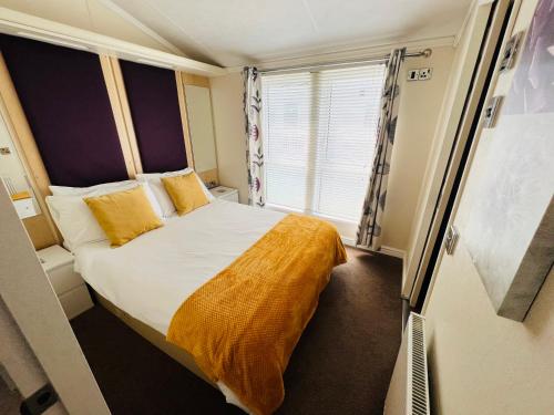 a small bedroom with a bed and a window at 2 Bedroom Lodge TH35, Nodes Point, St Helens, Isle of Wight in Saint Helens