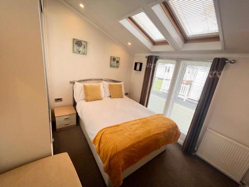 Habitación pequeña con cama y ventana en 2 Bedroom Lodge TH35, Nodes Point, St Helens, Isle of Wight, en Saint Helens