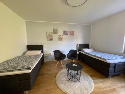 Habitación con 2 camas, mesa y sillas en KickEns, en Adenau