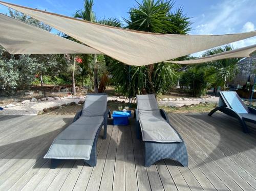 two benches sitting under a canopy on a deck at Don Genaro Apartments in Barber