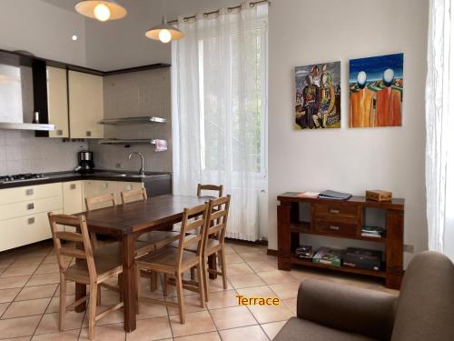 a kitchen with a wooden table and chairs in a room at Casa al Campanile, LeonardosHome in Trarego