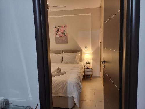 sypialnia z łóżkiem w pokoju z drzwiami w obiekcie Bovis Apartments #1 w mieście Markopoulo Mesogaias