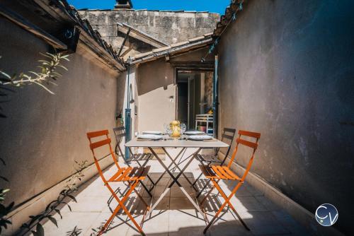 a table and two chairs on a patio at Maison de village atypique à 5min du Pont du Gard in Vers Pont du Gard