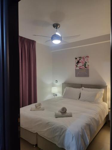 a bedroom with a large bed with two towels on it at Bovis Apartments #1 in Markopoulo