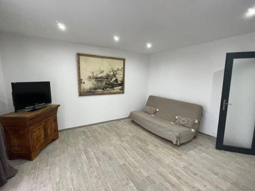 een woonkamer met een bank en een flatscreen-tv bij U Secondu Appart neuf spacieux au calme in Aléria