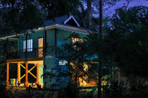 a blue house with a balcony on top of it at Manzanillo Caribbean Resort in Puerto Viejo