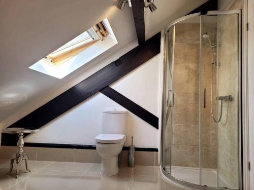 a bathroom with a toilet and a glass shower at Luxury Penthouse on Waterside Knaresborough in Knaresborough